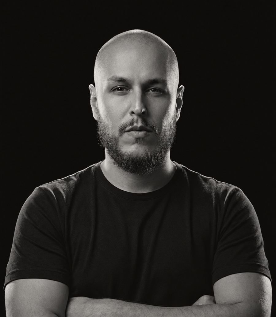 Anderson Demjän, fundador da DBM, de braços cruzados em retrato preto e branco